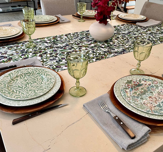 Mesa puesta con camino de aceitunas y vajilla estampada