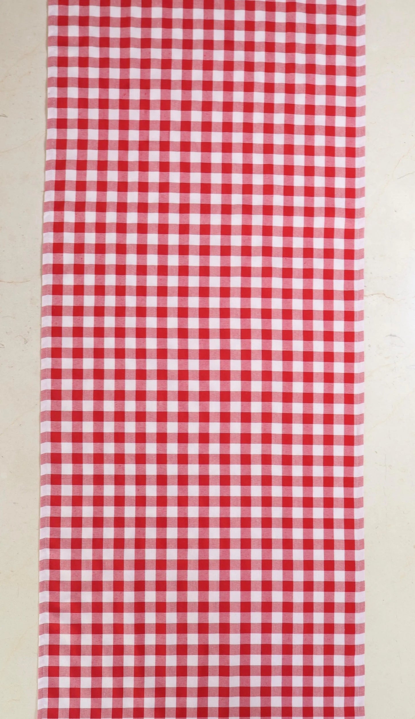 Camino de mesa con diseño de cuadros rojos y blancos sobre mesa de mármol