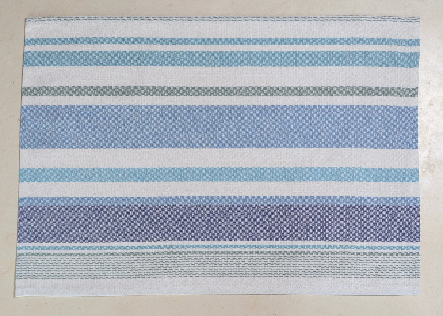 Mantel individual rayas azul y blanco sobre mesa de comedor