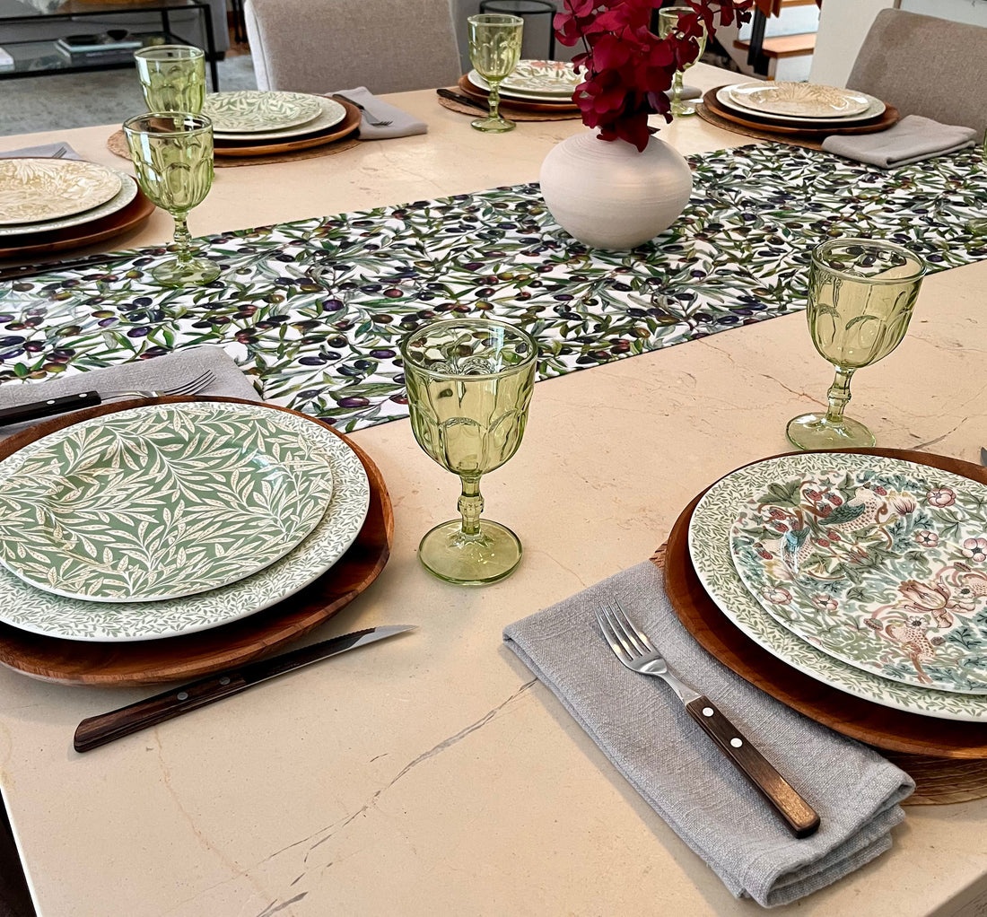 Mesa puesta con camino de aceitunas y vajilla estampada