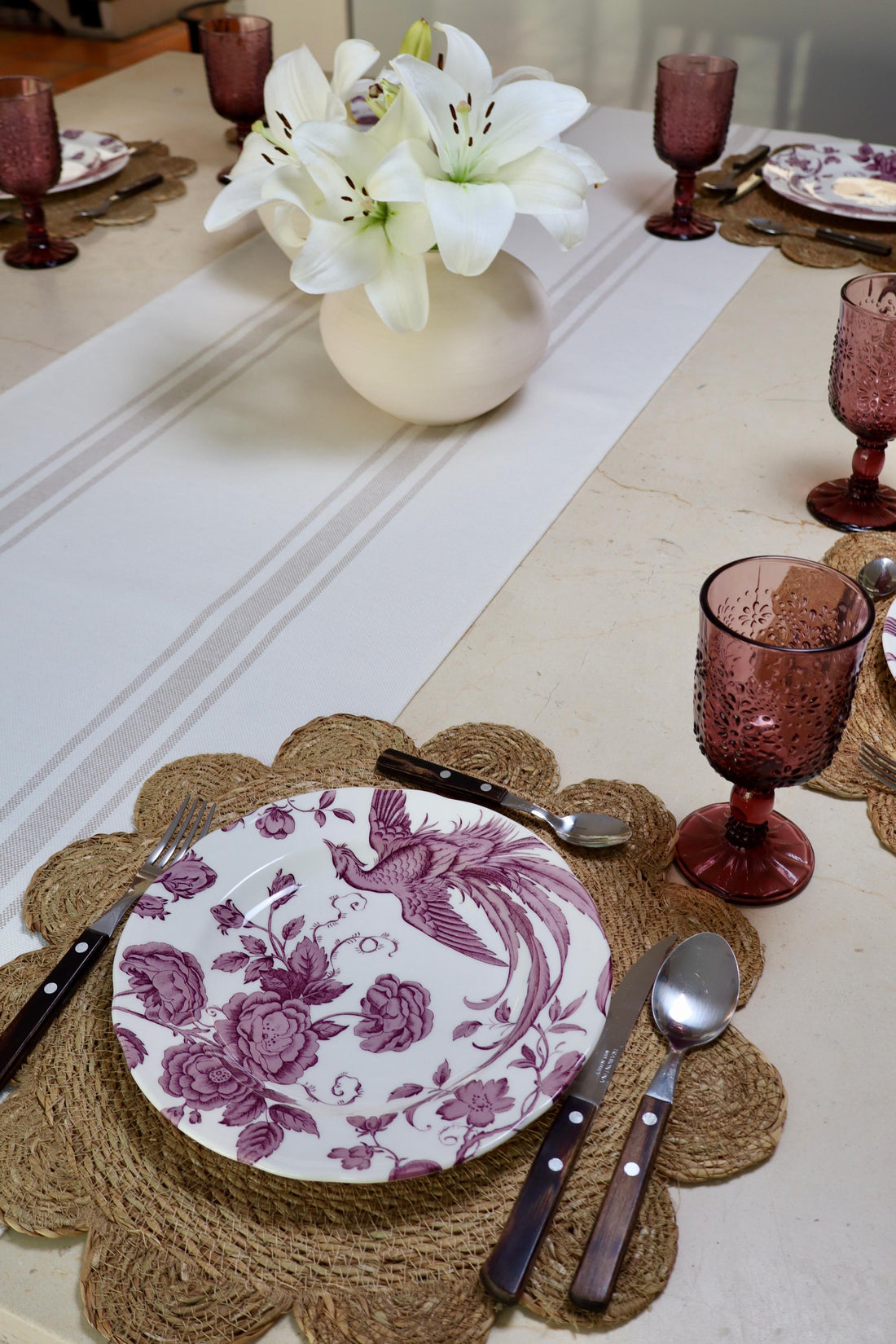 Mesa elegante decorada al estilo de lujo, con vajilla fina y detalles exclusivos para recibir invitados.