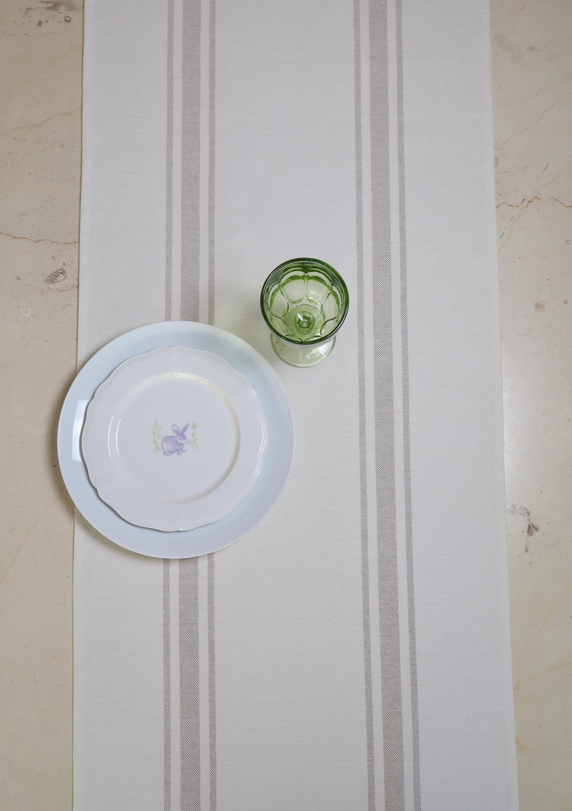 camino de mesa rayas beige con vajilla blanca
