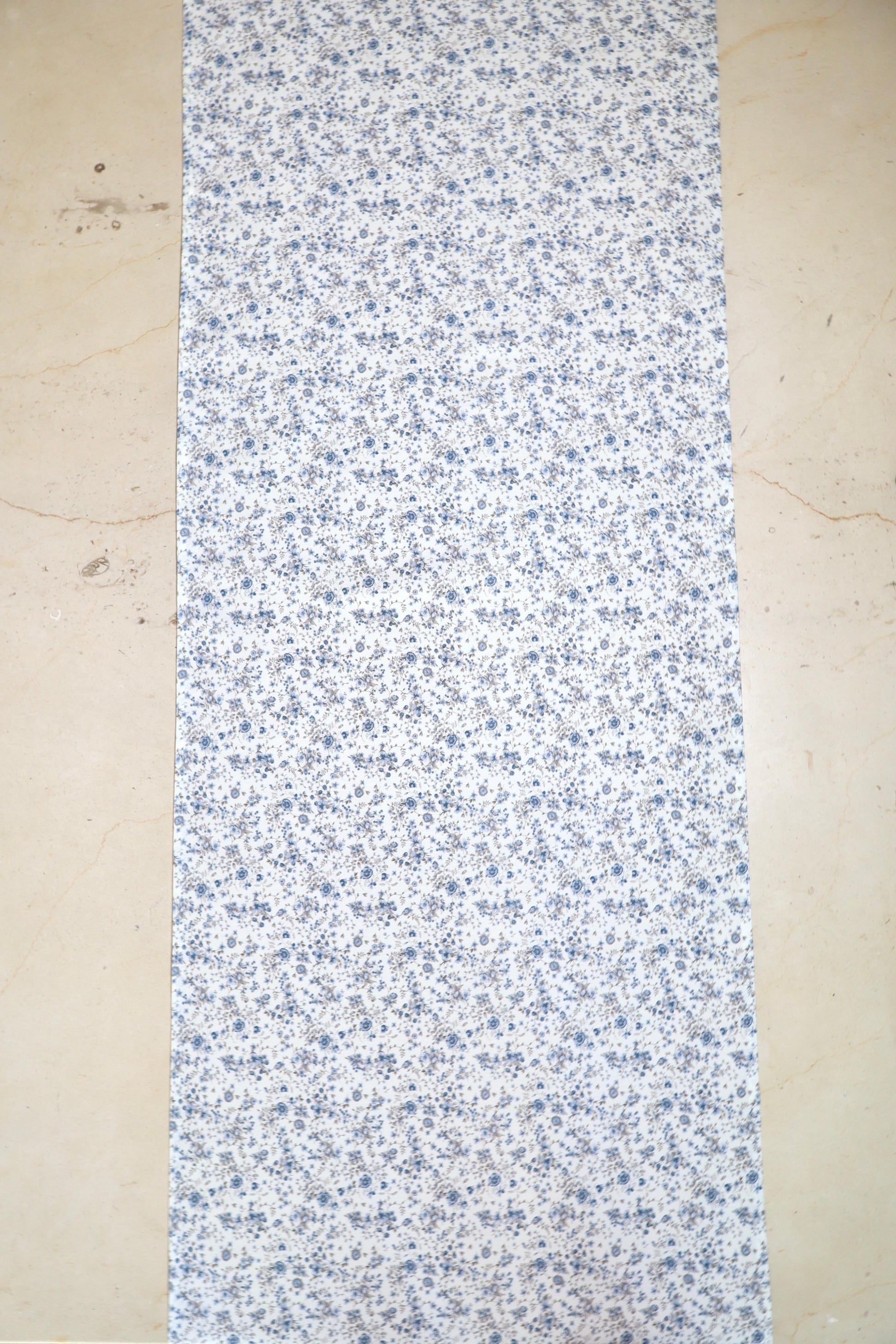 Camino de mesa con diseño floral en tonos azules sobre fondo blanco sobre mesa
