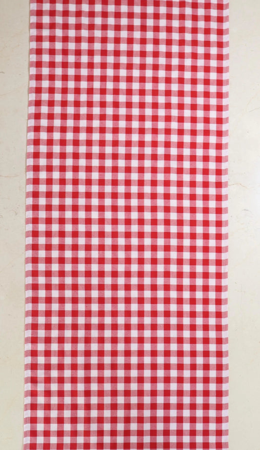 Camino de mesa con diseño de cuadros rojos y blancos sobre mesa de mármol
