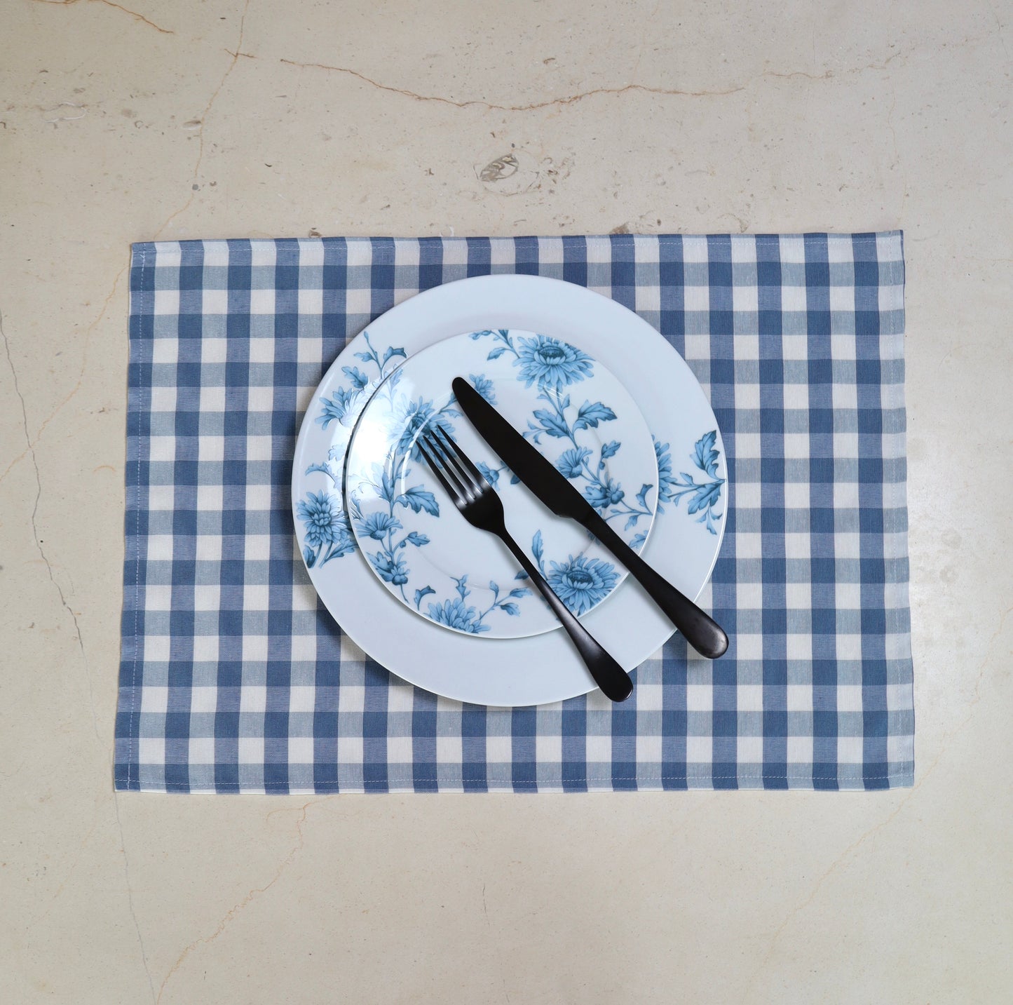 Primer plano de la tela con patrón de cuadros azul y blanco en mantel individual
