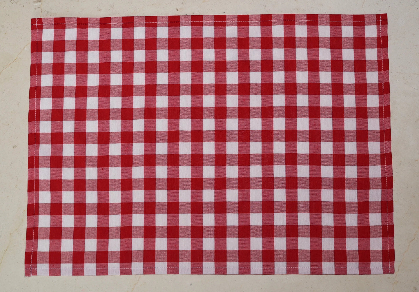 Mantel individual con diseño de cuadros rojos y blancos sobre mesa de comedor
