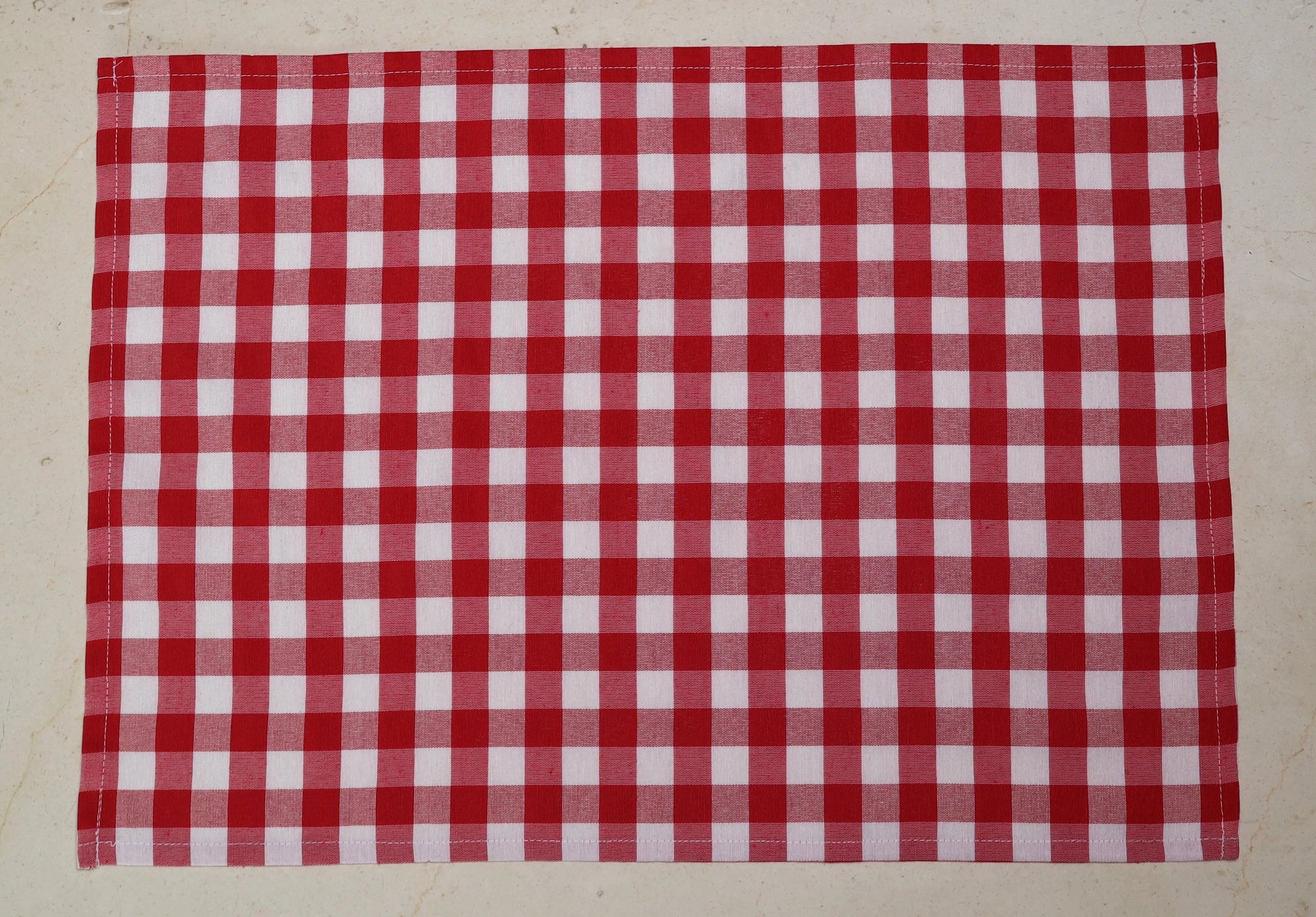 Mantel individual con diseño de cuadros rojos y blancos sobre mesa de comedor

