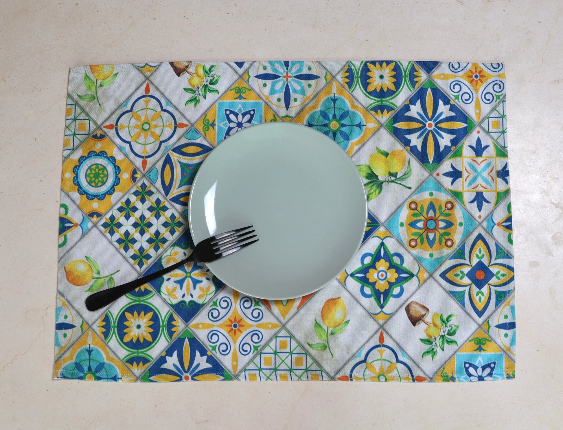 Primer plano del estampado de azulejos en tonos azules y amarillos del mantel individual
