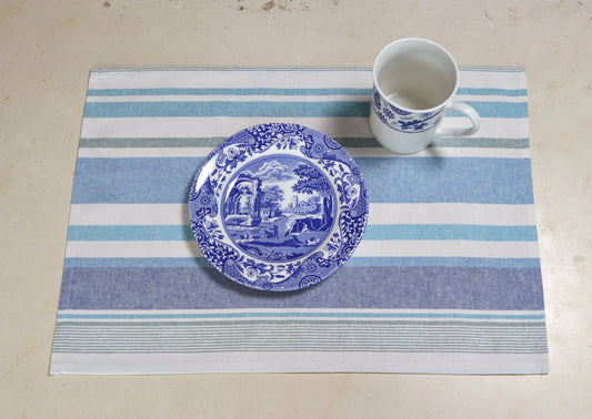 Mantel individual con diseño de rayas azul y blanco sobre mesa de madera

