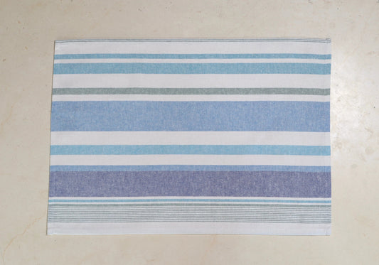 Mantel individual con diseño de rayas azul y blanco sobre mesa de mármol
